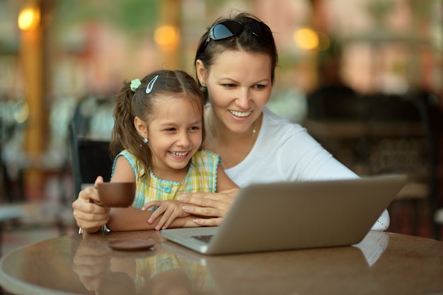 Jeune femme avec une fille à l'aide d'un ordinateur portable