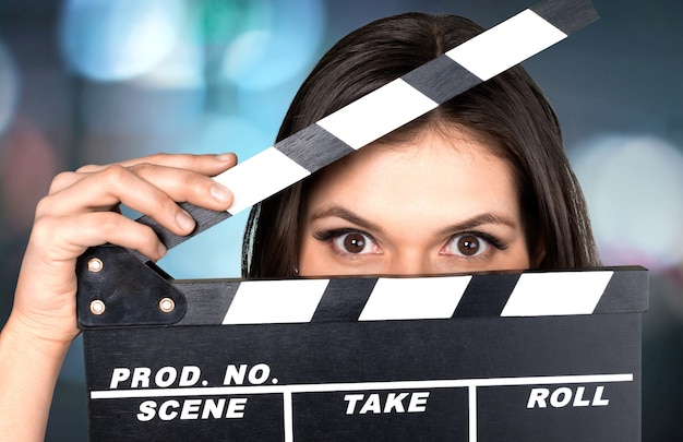 Photo jeune femme avec film battant isolé