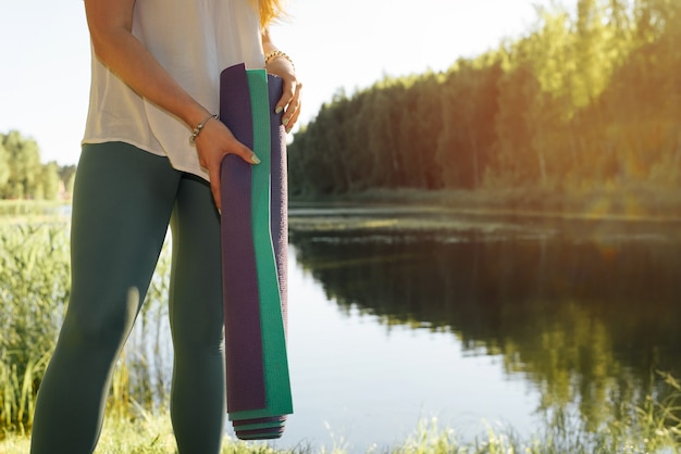 jeune femme fitness debout au bord du lac avec yoga matsyoga dans la nature en plein air