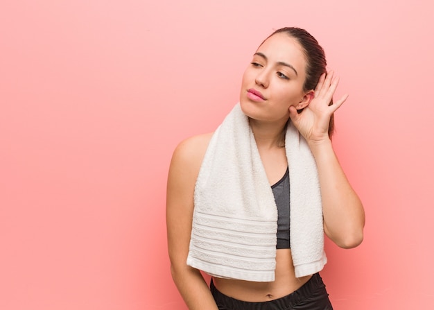 Jeune femme fitness essaie d&#39;écouter un potin