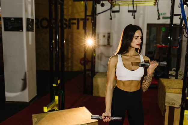 Jeune femme fitness exécuter l'exercice avec exercisemachine Cable Crossover dans la salle de gym photo horizontale