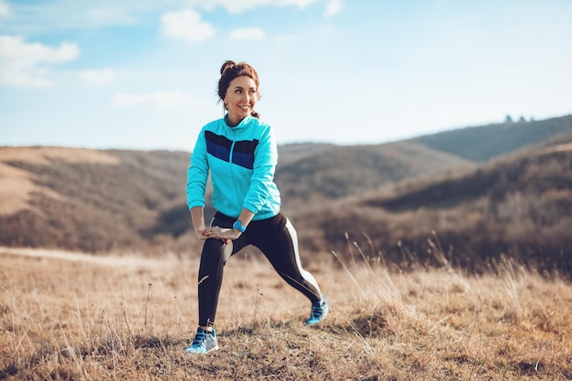 Jeune femme de fitness faisant des exercices d'étirement après avoir fait du jogging dans la nature.