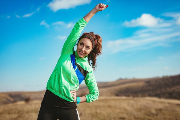 Jeune femme de fitness faisant des exercices d'étirement après avoir fait du jogging dans la nature.