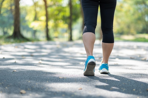 Jeune femme fitness jambes marchant dans le parc en plein air