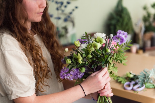 Jeune femme fleuriste travailler avec des fleurs au milieu de travail petite entreprise concept lifestyle recadrée portrait fleurs close up