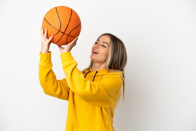 Jeune femme sur fond blanc isolé jouant au basket-ball