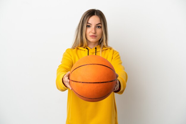 Jeune femme sur fond blanc isolé jouant au basket-ball