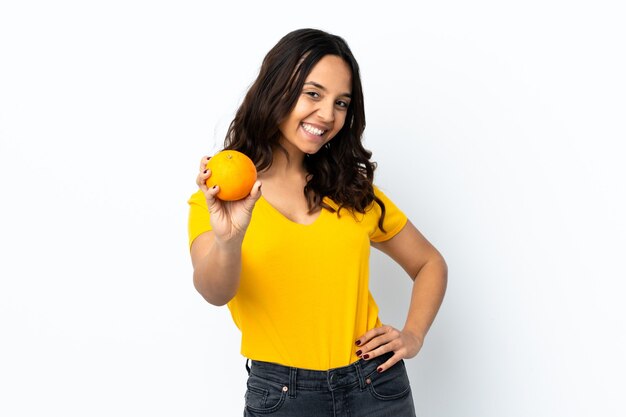 Jeune femme sur fond blanc isolé tenant une orange