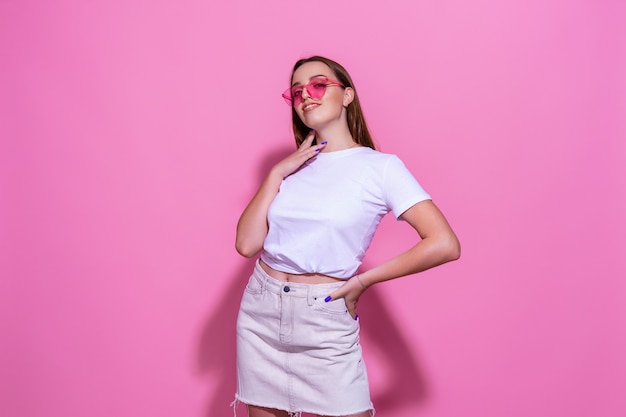 Jeune femme sur fond rose isolé avec des lunettes