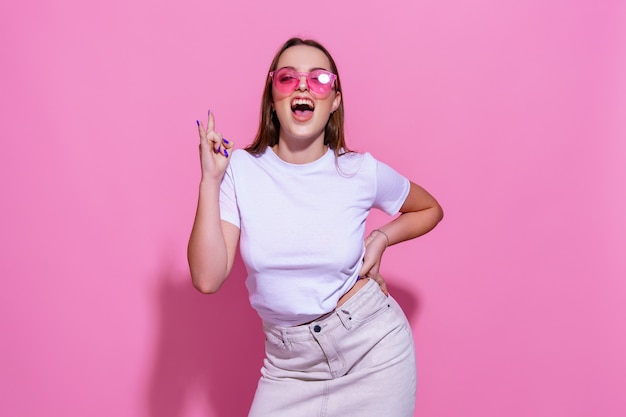 Jeune femme sur fond rose isolé avec des lunettes