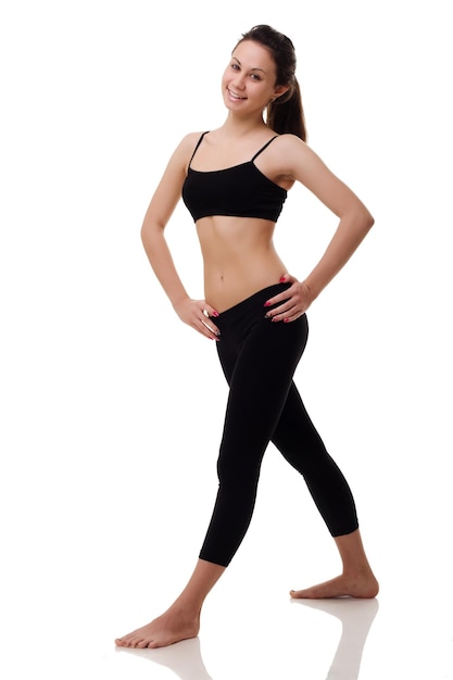 Jeune femme en forme et belle brune en vêtements de sport isolé sur gris Concept de sport et de remise en forme de régime de soins de santé