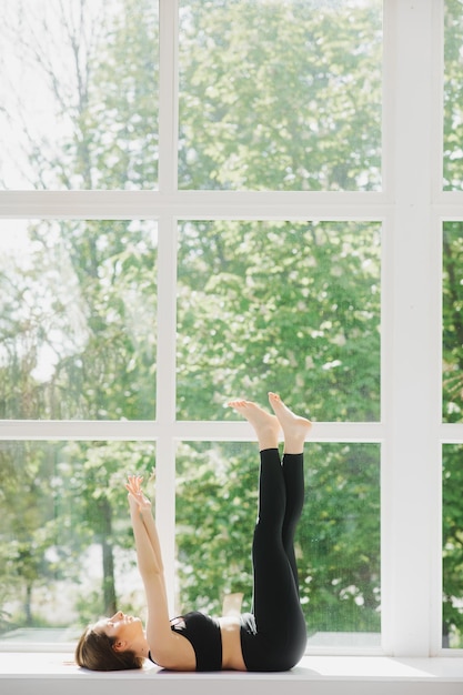 Jeune femme en forme faisant des exercices de relaxation dans la chambre