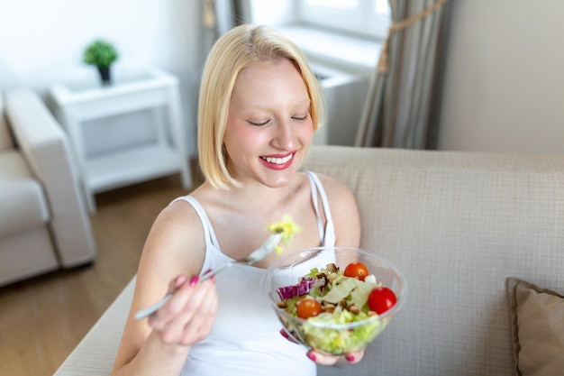 Jeune femme en forme mangeant une salade saine après l'entraînement Fitness et concept de mode de vie sain jeune femme en bonne santé mangeant une salade verte