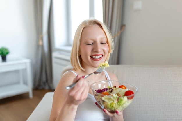 Jeune femme en forme mangeant une salade saine après l'entraînement Fitness et concept de mode de vie sain jeune femme en bonne santé mangeant une salade verte