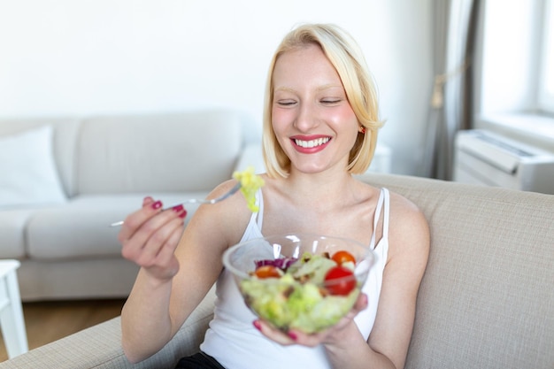 Jeune femme en forme mangeant une salade saine après l'entraînement Fitness et concept de mode de vie sain jeune femme en bonne santé mangeant une salade verte