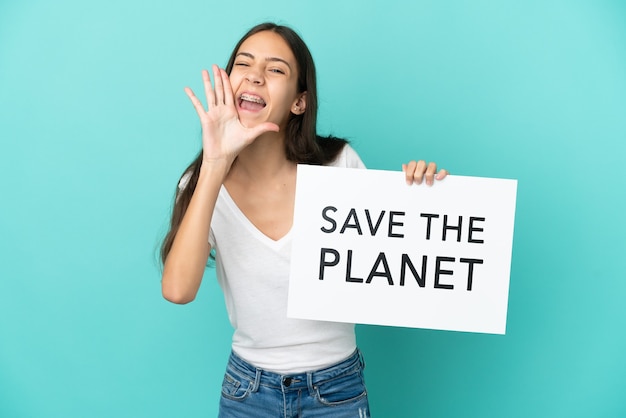 Jeune femme française isolée sur fond bleu tenant une pancarte avec texte Save the Planet et criant