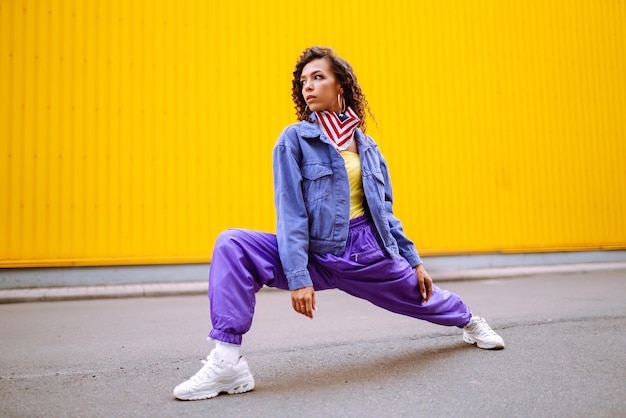 Jeune femme funky avec bandana américain dansant seule dans la rueDanse sportive et culture urbaine