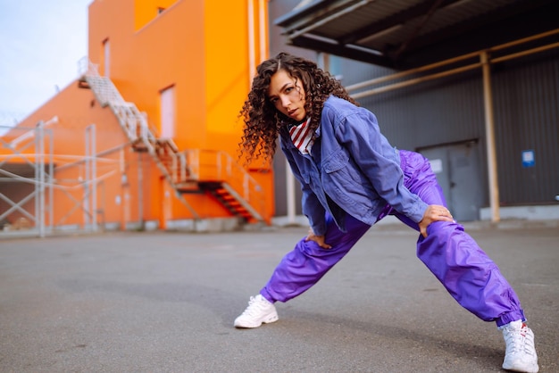 Jeune femme funky avec bandana américain dansant seule dans la rueDanse sportive et culture urbaine