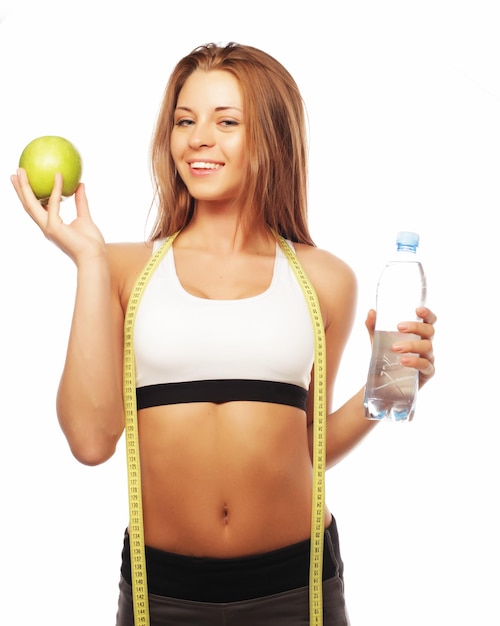 Jeune femme gaie en vêtements de sport avec pomme et une bouteille d'eau