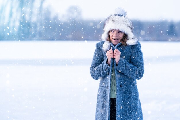 Jeune femme gelée sur le lac glacé d'hiver