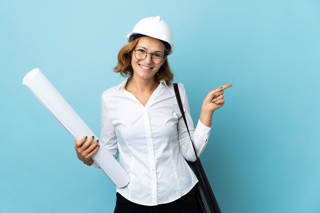 Jeune femme géorgienne architecte avec casque et tenant des plans isolés