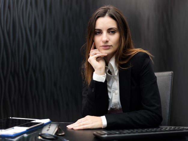 Jeune femme gestionnaire assis un bureau ther dans un bureau moderne