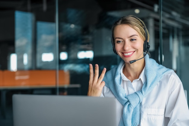 Jeune femme gestionnaire dans les écouteurs ayant un appel vidéo