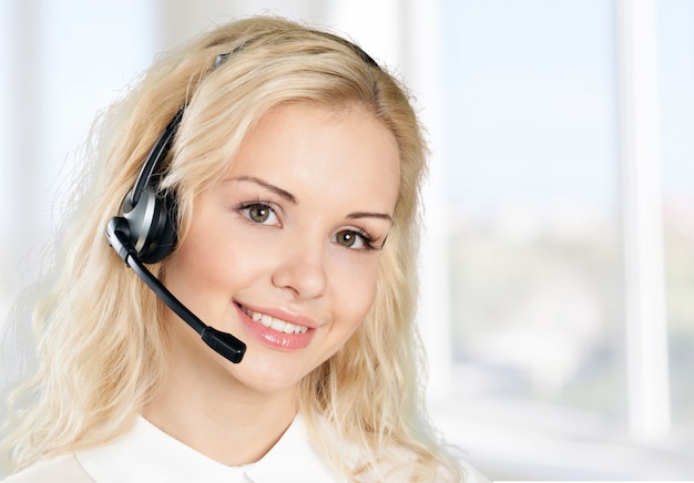 Jeune femme gestionnaire de service téléphonique sur fond de bureau flou