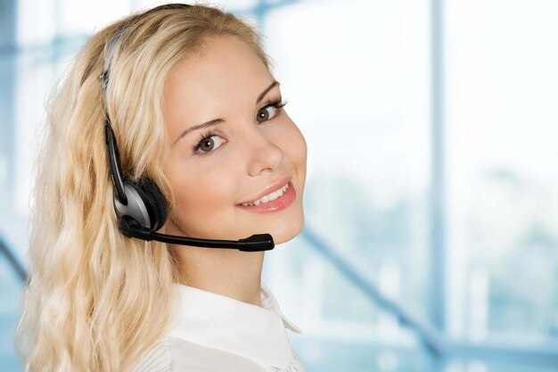 Jeune femme gestionnaire de service téléphonique sur fond de bureau flou