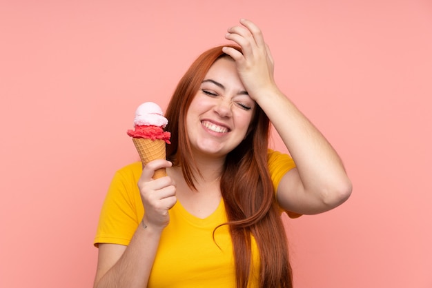 Jeune femme avec une glace au cornet sur un mur isolé a réalisé quelque chose et a l'intention de la solution