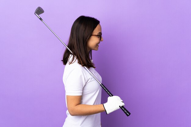 Jeune femme golfeur sur coloré en position latérale