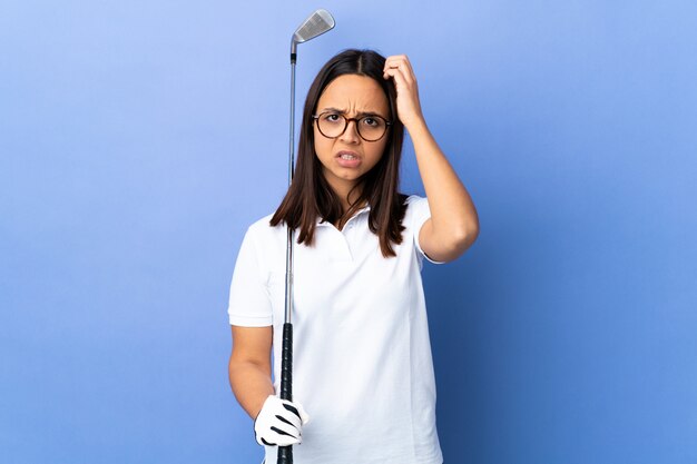 Jeune femme golfeur sur mur coloré avec une expression de frustration et de ne pas comprendre