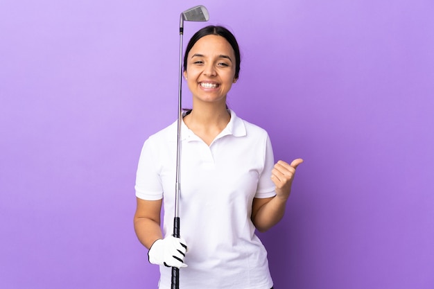 Jeune femme de golfeur sur mur coloré isolé avec le pouce en l'air et souriant