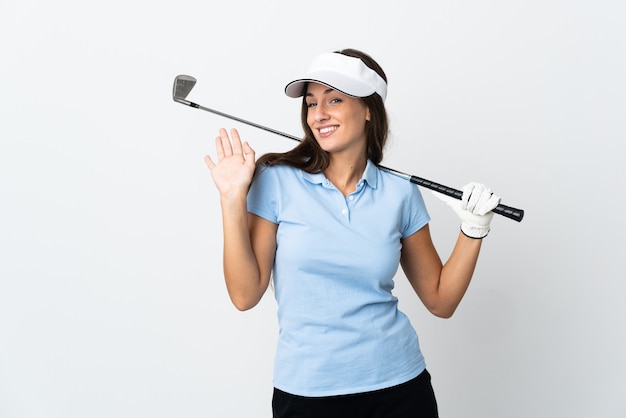 Jeune femme golfeuse sur fond blanc isolé saluant avec la main avec une expression heureuse