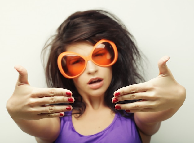 Jeune femme avec de grandes lunettes de soleil orange