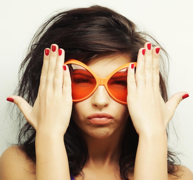 Jeune femme avec de grandes lunettes de soleil orange