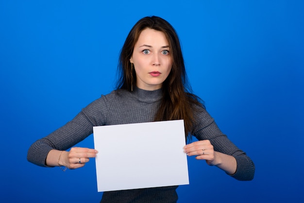 Jeune, femme, gris, chemise, tenue, feuille, papier, regarder