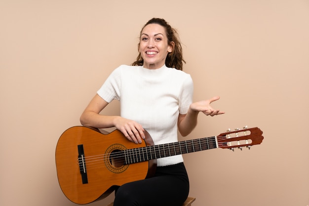 Jeune femme avec une guitare avec une expression faciale choquée