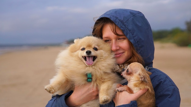 Photo une jeune femme heureuse ou une adolescente qui marche avec ses deux animaux de compagnie, un chien spitz poméranien et un chihuahua.