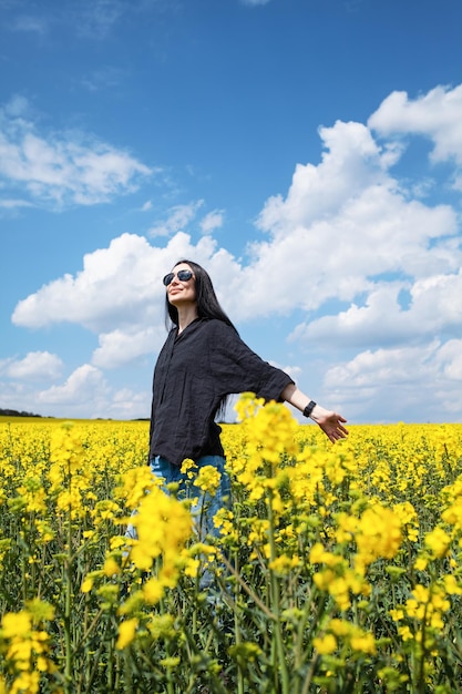 Jeune femme heureuse appréciant le champ de canola.