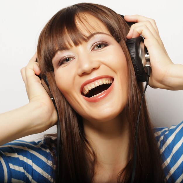 Jeune femme heureuse avec un casque d'écoute de la musique