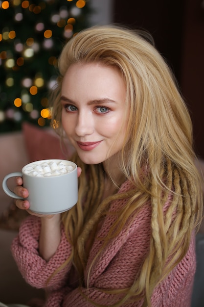 Jeune femme heureuse célébrant Noël à la maison