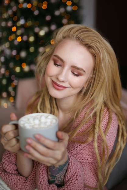 Jeune femme heureuse célébrant Noël à la maison