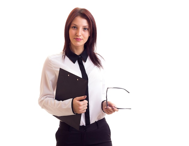 Jeune femme heureuse en chemise et pantalon avec de longs cheveux noirs et des lunettes noires tenant un dossier