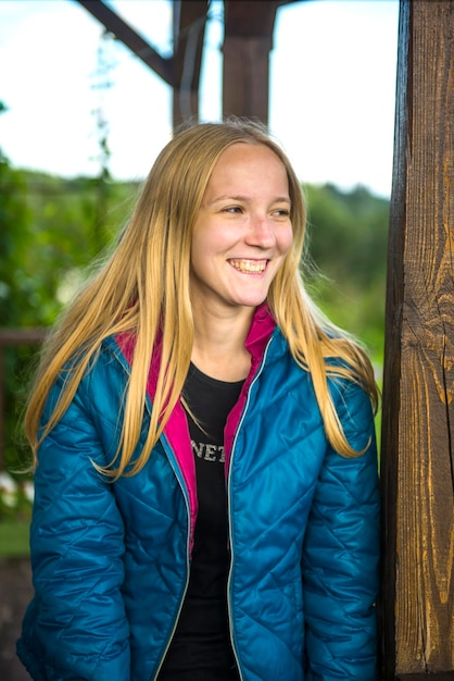 Une jeune femme heureuse debout contre un arbre.