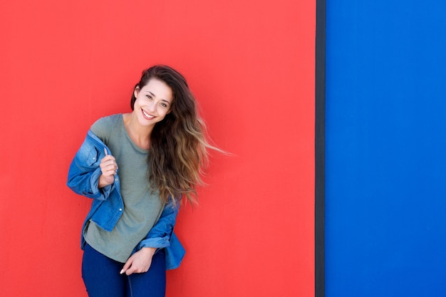 Jeune femme heureuse, debout sur un fond bleu et rouge