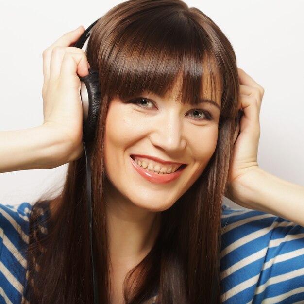 Jeune femme heureuse avec des écouteurs écoutant de la musique