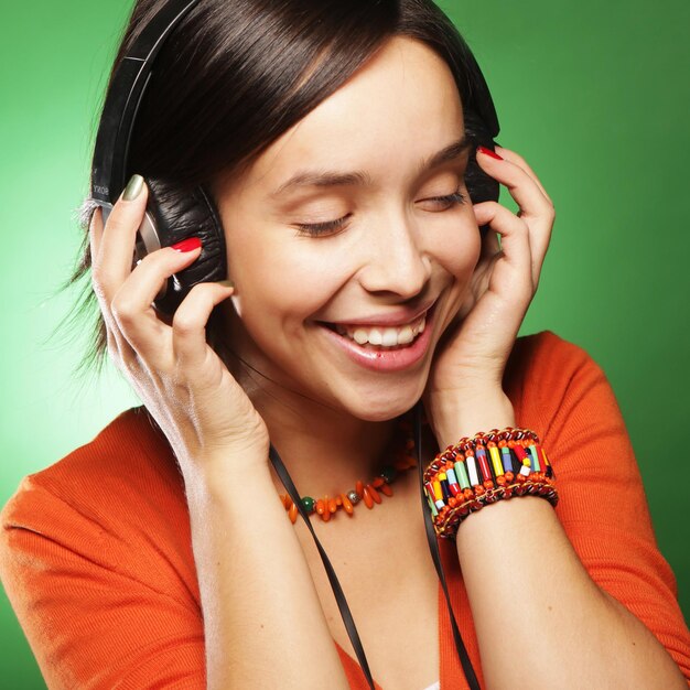 Jeune femme heureuse avec des écouteurs écoutant de la musique