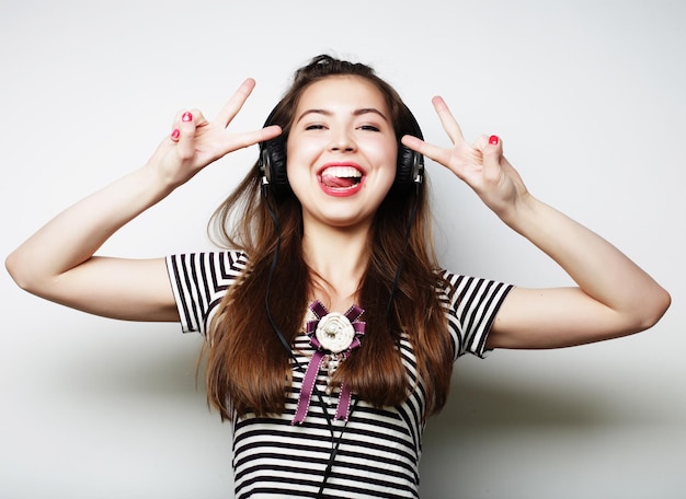 Une jeune femme heureuse avec des écouteurs écoutant de la musique