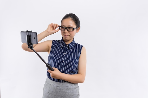 La jeune femme heureuse fait des selfies avec le téléphone intelligent